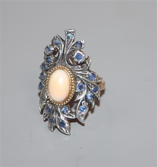 A 20th century continental? yellow and white metal mounted sapphire and cabochon coral upfinger dress ring, size N.